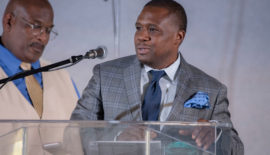 A man in a suit and tie standing at a podium.